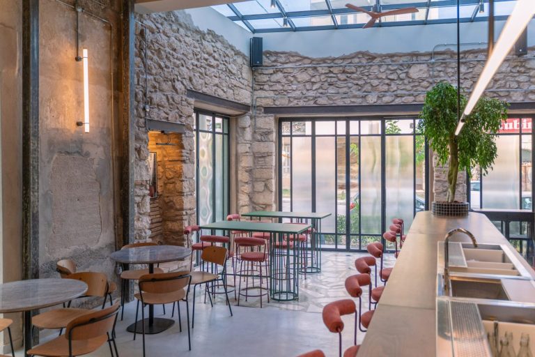 The inviting interior of Felicità in Rouf with Aperol spritzes on rustic wooden tables.