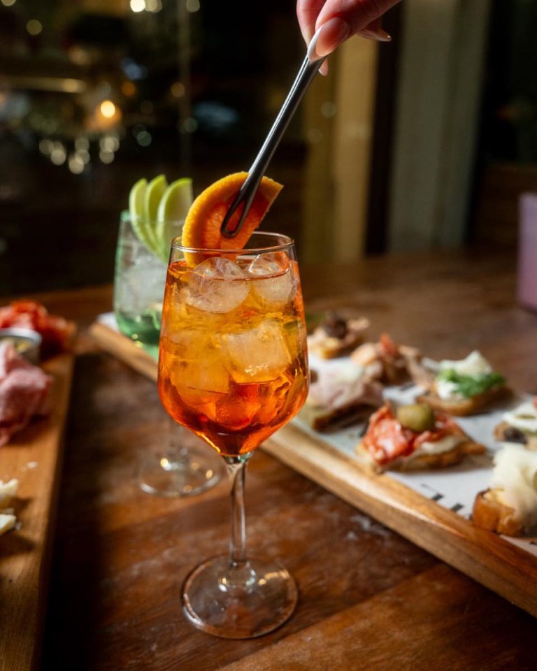 Zyme Spritzeria in Piraeus with colorful spritzes and small Italian plates on the counter.